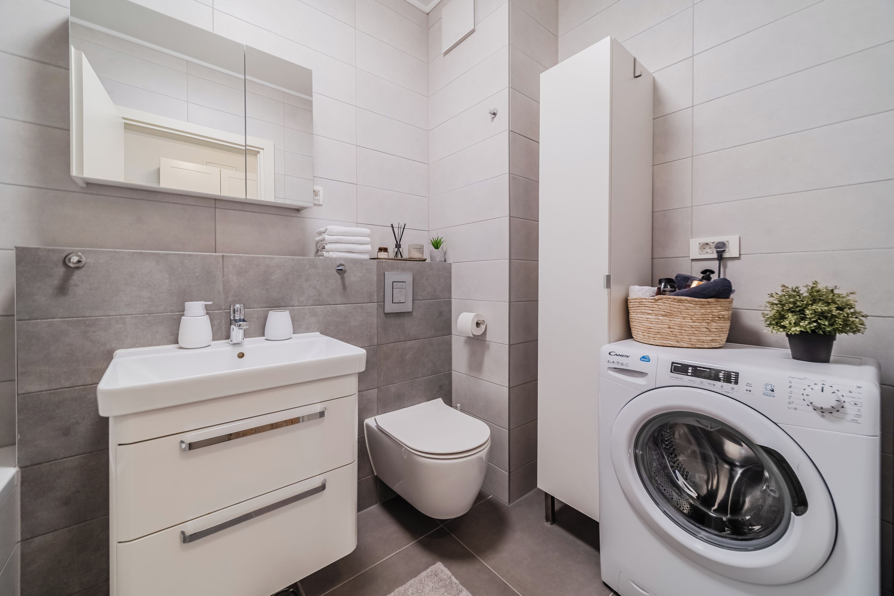 Un bagno moderno con lavandino, wc e lavatrice.