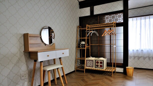 A room with a wooden desk, a chair, a mirror, a wardrobe with a hanging rack, and a radiator. - KAKENKAN (Miyazu)