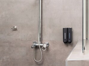 Een douche, handdoeken, zeep, shampoo