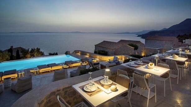 Ein Essbereich im Freien mit Pool und Meerblick.