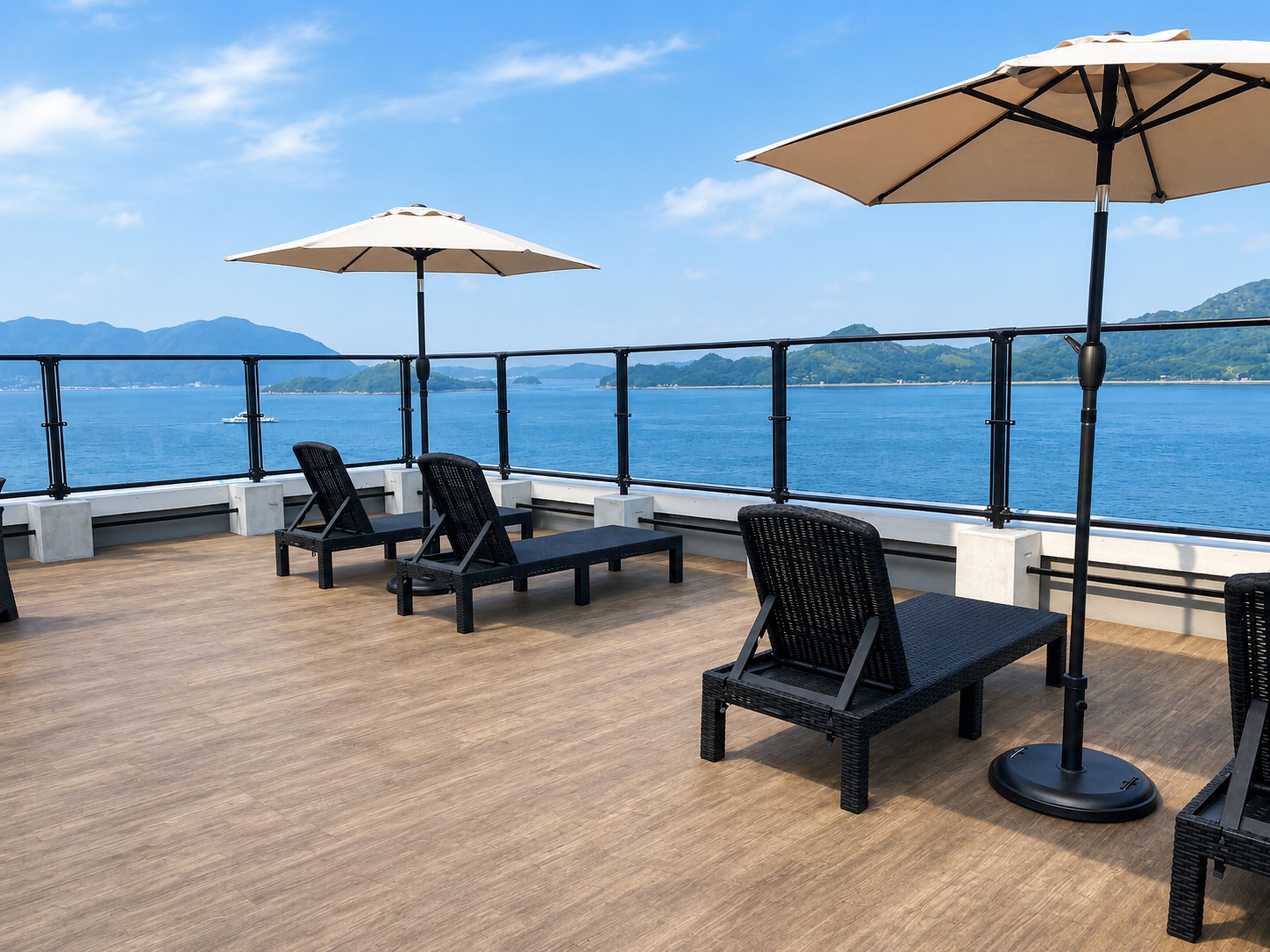A deck with outdoor seating and a view of the sea.