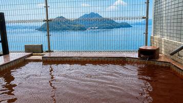 A hot spring area with a view of a mountainous landscape through a wire mesh.