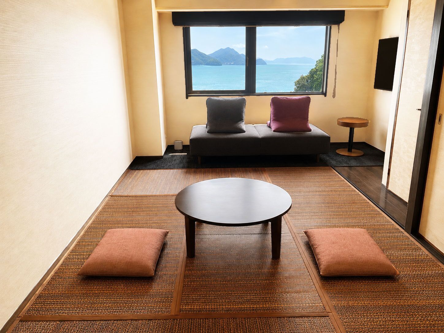 Una habitación con sofá, una mesita y vista al mar.