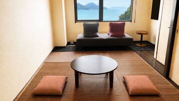 Una habitación con sofá, una mesita y vista al mar.