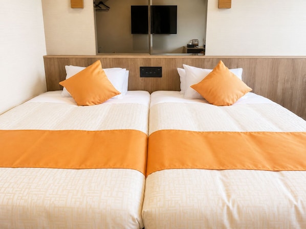 A hotel room with two beds, each with white bedding and orange accents, a flat-screen TV mounted on the wall, and a wooden headboard. - Livemax Resort Mihara Sea Front (Mihara)