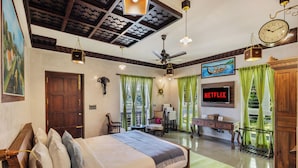 Un dormitorio con cama, escritorio, televisión y ventilador de techo.