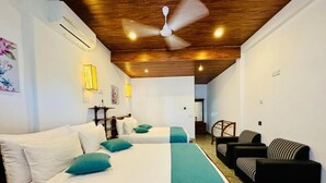A hotel room with two beds, a ceiling fan, a sofa, and a lamp. - Nest of peak  (Ella)