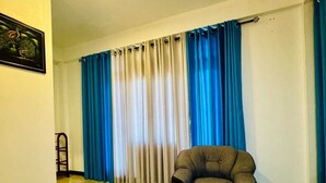 A room with a bed, a chair, and a window with curtains. - Nest of peak  (Ella)