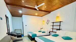 A hotel room with two beds, a sofa, a ceiling fan, and a wooden floor. - Nest of peak  (Ella)