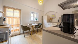 Eine moderne Küche mit Kaffeemaschine, Kühlschrank und Mikrowelle. Es gibt einen Essbereich mit Tisch und Stühlen.