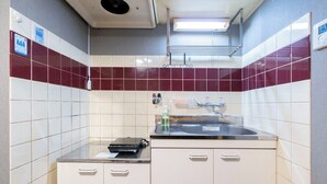 Ett litet pentry med en diskho, skåp och en mikrovågsugn.