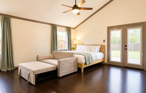 A bedroom with a bed, a sofa, a ceiling fan, and a sliding glass door leading to a patio. - Central Location - Heights & Downtown 5 Mins - 3BR - Groups, Family, Yard, Pets (Houston)