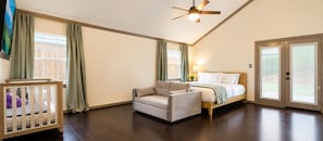 A bedroom with a bed, a chair, a crib, and a ceiling fan. - Central Location - Heights & Downtown 5 Mins - 3BR - Groups, Family, Yard, Pets (Houston)