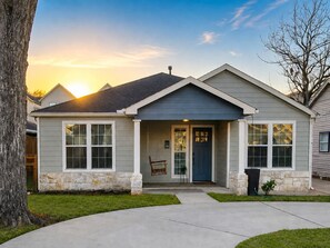 A residential house with a front porch, stone foundation, and a garage. - Central Location - Heights & Downtown 5 Mins - 3BR - Groups, Family, Yard, Pets (Houston)