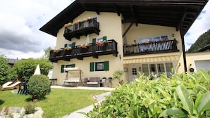 A two-story building with balconies, outdoor seating, and a well-maintained garden. - Tranquil Apartment in the Centre of Seefeld (Seefeld in Tirol)