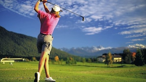 A person playing golf on a course with a mountainous backdrop. - Tranquil Apartment in the Centre of Seefeld (Seefeld in Tirol)