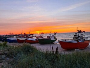 Une rangée de bateaux était amarrée  à un quai au coucher du soleil.