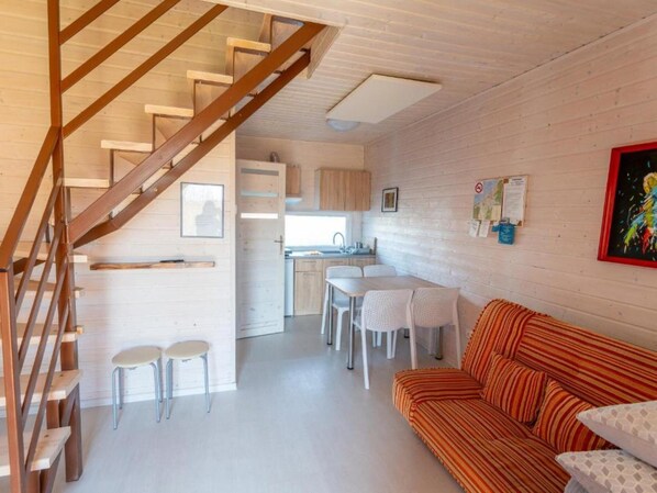 Un intérieur moderne comprenant un escalier, un coin repas et un salon avec un canapé.