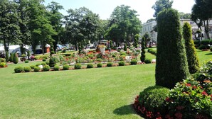 Un jardín bien cuidado con setos recortados y macizos de flores.