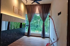 A hotel room with a wooden floor, a ceiling fan, a window with curtains, and a wall-mounted light fixture. - 4BR 16pax LYL Jaccuzi Private Pool House ipoh (Ipoh)