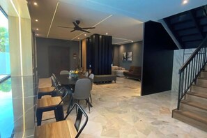 A modern living room with a dining area, a staircase, and a ceiling fan. - 4BR 16pax LYL Jaccuzi Private Pool House ipoh (Ipoh)