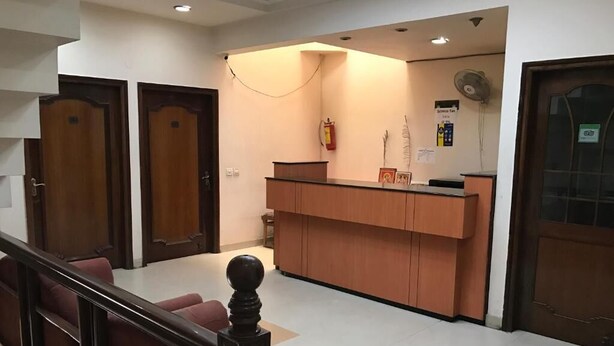 Un espace d’accueil avec un comptoir en bois, un extincteur et un panneau sur le mur.