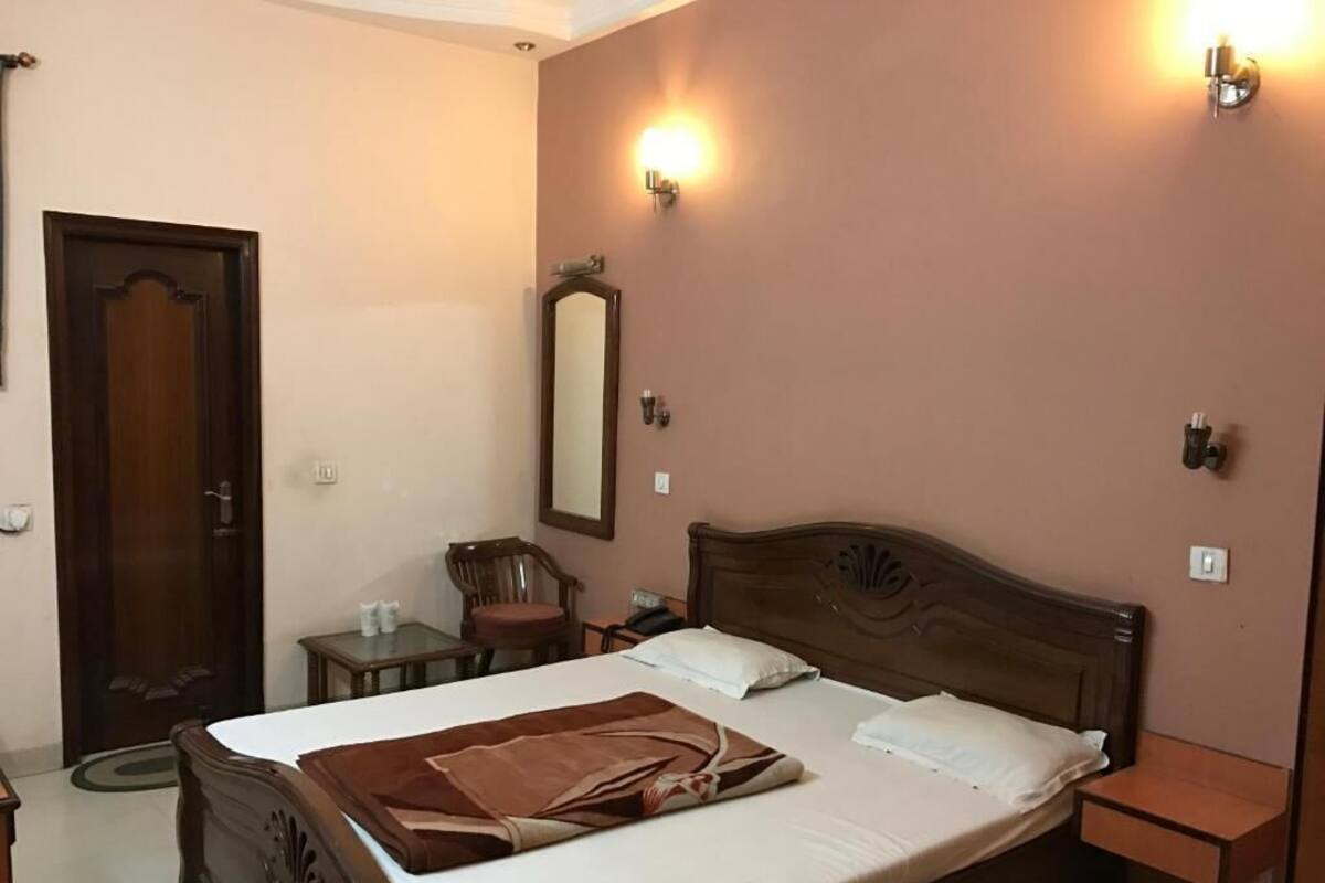 Camera da letto con un letto in legno, comodini, uno specchio e applique.