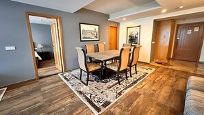A dining area with a table and chairs, a patterned rug, and a wooden floor. - Centaurus Ultra Luxury Apartments (Islamabad)