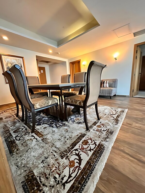 Un espace repas comprenant une table, des chaises et un tapis à motifs.