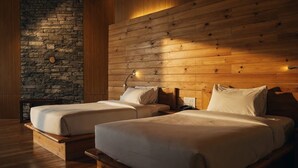 A room with two beds, wooden walls, a stone accent wall, and a nightstand with a lamp. - Mountain Resort (Jakar)