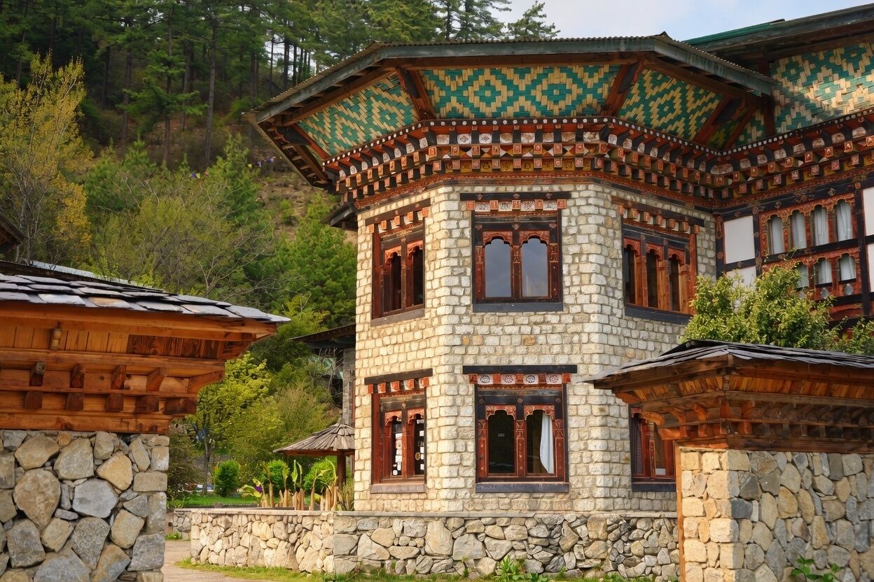 Un bâtiment traditionnel en pierre, doté d’une structure supérieure en bois, de nombreuses fenêtres et d’une base en pierre.
