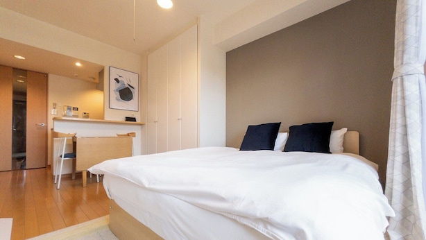 A hotel room with a large bed, a desk, and a chair. - CITYSPIRE Namba WEST (Osaka)