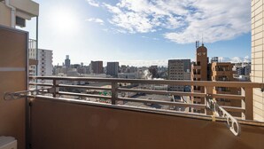 A balcony with a cityscape view, including a building with a tower and a signboard. - CITYSPIRE Namba WEST (Osaka)