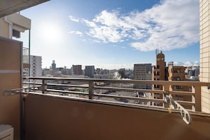 Ein Balkon mit Blick auf die Stadt, darunter ein Gebäude mit einem Turm und einer Schautafel.