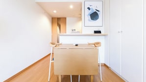 A minimalist room with a wooden desk, a chair, a shelf with a framed picture, and a wardrobe. - CITYSPIRE Namba WEST (Osaka)