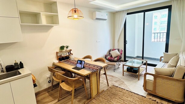 A modern apartment with a dining area, a sofa, a coffee table, and a large window. - Boho and Cozy Home in Sapa -5Min to Center (Sapa)