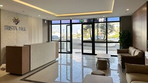 A modern reception area with a reception desk, seating area, and large windows. - Boho and Cozy Home in Sapa -5Min to Center (Sapa)