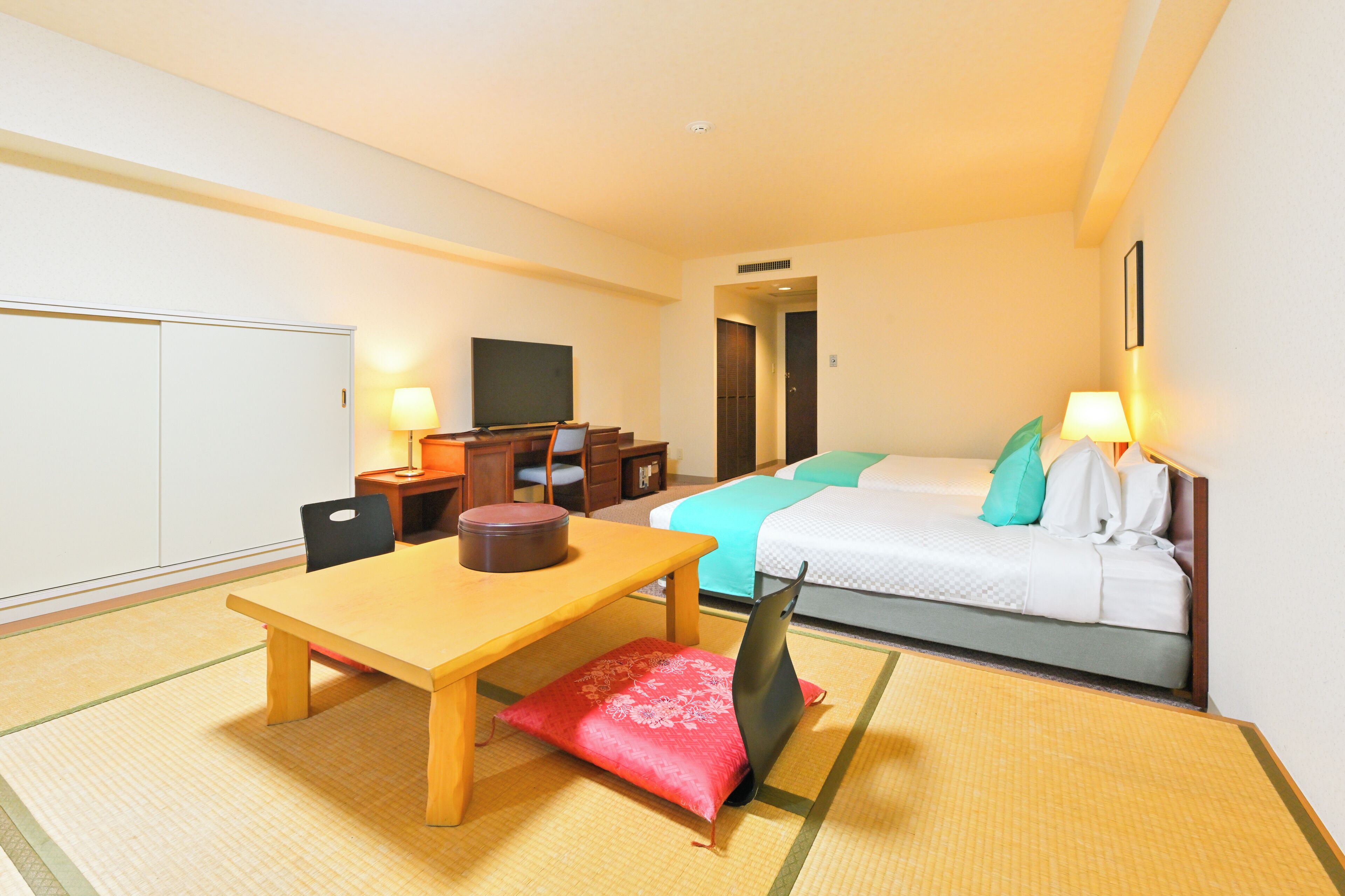 Une chambre d’hôtel équipée d’un lit, d’un bureau, d’une chaise, d’une télévision et d’une lampe.