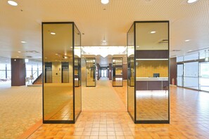 A spacious lobby with a tiled floor, a reception desk, and a staircase in the background. - Livemax Resort Hachimantai (Hachimantai)