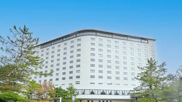 A multi-story hotel with a modern design, featuring a curved facade and numerous windows.