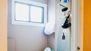 Um banheiro pequeno com vaso sanitário, janela e toalha pendurada na parede.