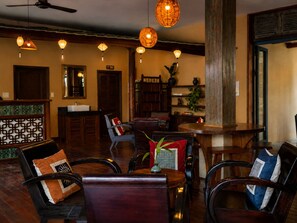 A hotel lobby with a reception desk, seating area, and a bar. - Sola Hoi An (Da Nang Municipality)
