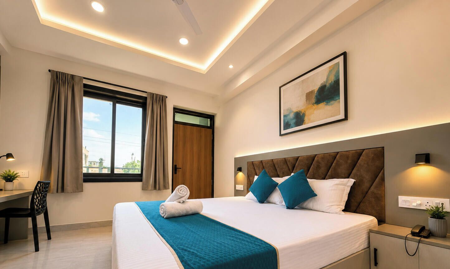Une chambre d’hôtel moderne avec un grand lit, un bureau, une chaise et une fenêtre avec des rideaux.