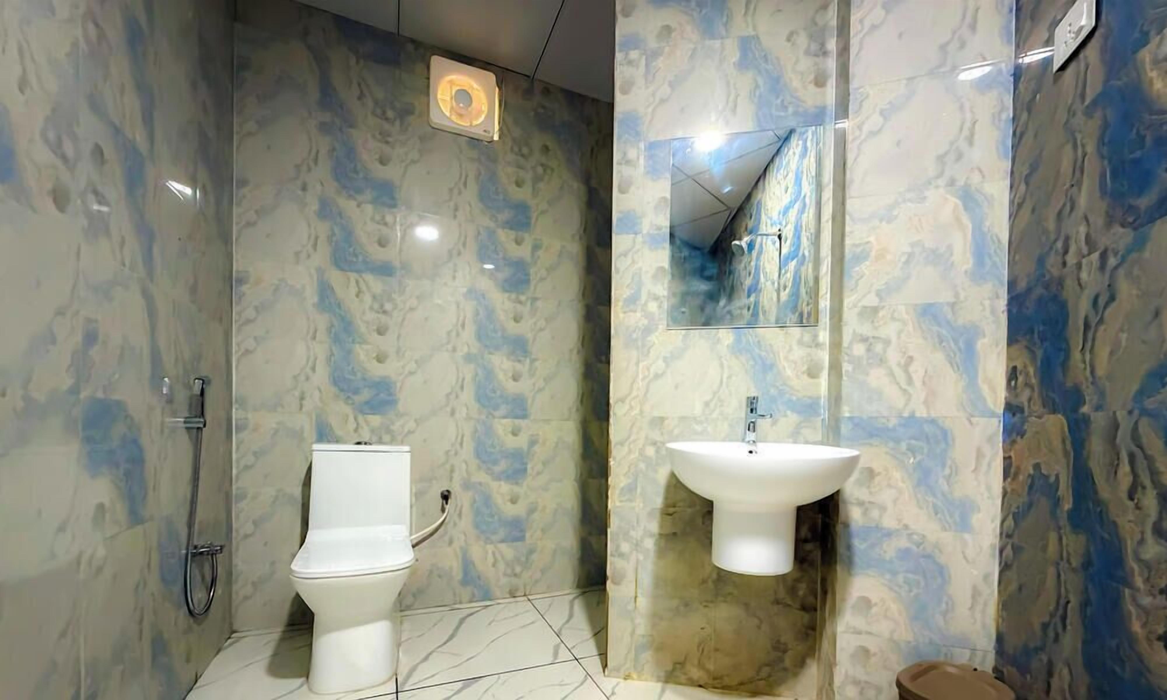 A bathroom with a toilet, sink, and shower.