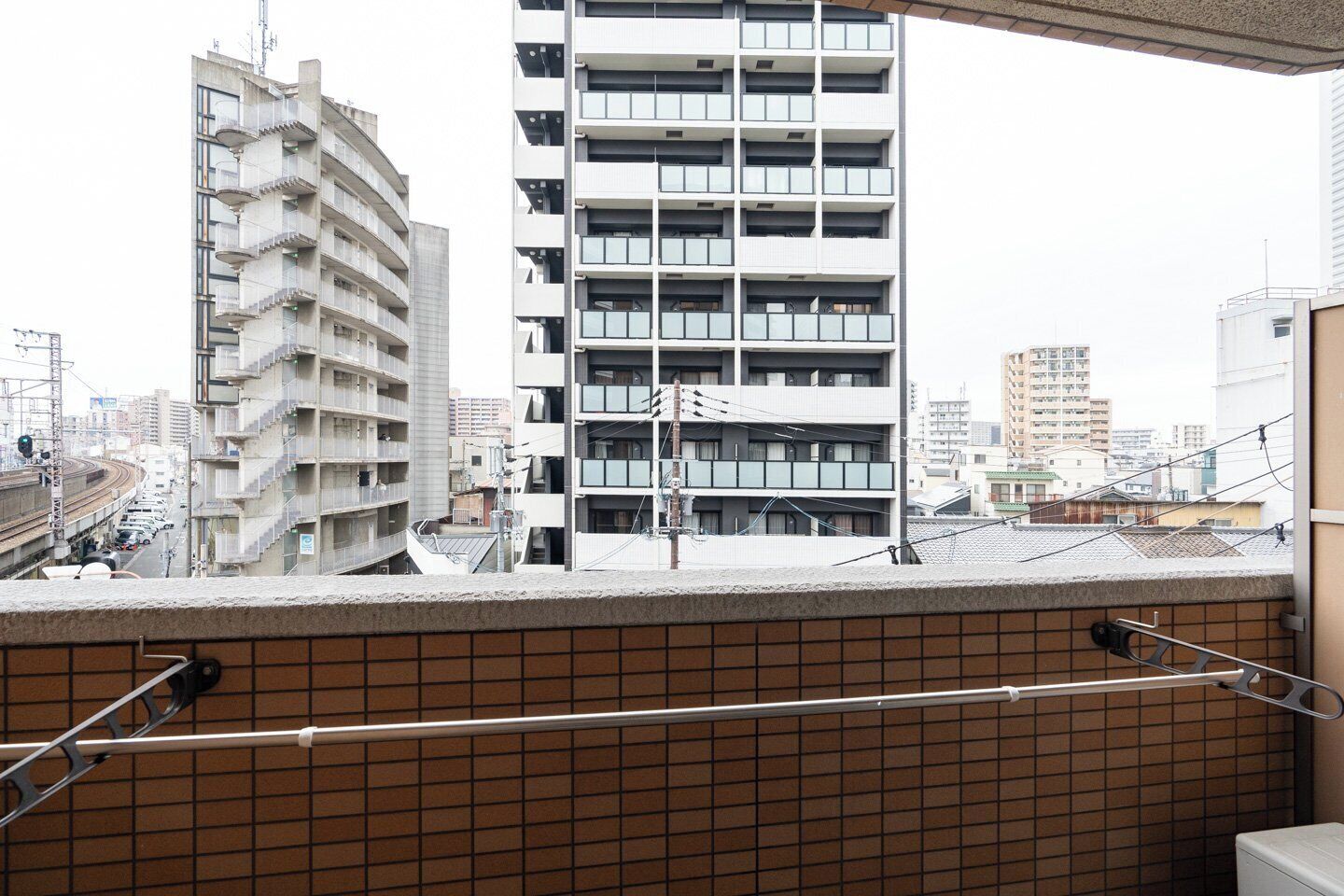 A high-rise building with multiple balconies, a tiled wall, and a metal railing.