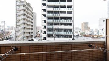 A high-rise building with multiple balconies, a tiled wall, and a metal railing.