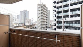 A high-rise building with multiple balconies, a tiled wall, and a metal railing.
