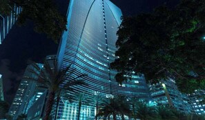 A high-rise building with a curved facade, surrounded by palm trees. - Huge 2-Story Brickell Penthouse Free Parking Pool (Miami)