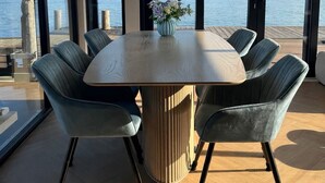A dining area with a round table, six chairs, and a vase of flowers. - Unique stay on the water, houseboat Loosdrecht (Loosdrecht)