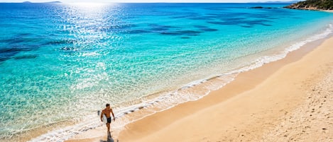 On the beach, white sand, beach towels, 2 beach bars